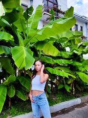 young woman long hair model behind palm trees - 562408072