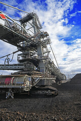 Bucket-wheel excavator during excavation at the surface mine. Huge excavator on open pit mine.