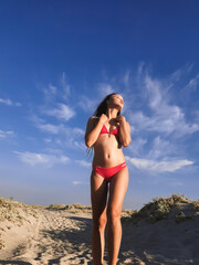 Portrait of beautiful woman in swimsuit standing on beach - 562412411