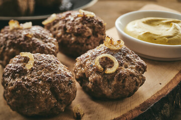 Patties with onion near mustard