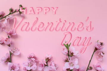 Blossom tree branch and text 'Happy Valentine's Day' isolated on pink background. Celebration concept idea.