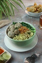 bowl containing boiled noodles, meatballs and vegetables