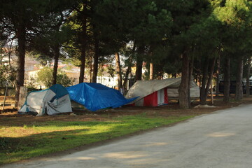 Some homeless tents in forest near road. Sad situation of America