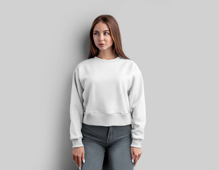 Mockup of a white female sweatshirt, a shirt on a girl in gray jeans, isolated on a background, front.