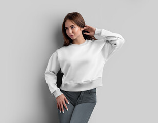 Mockup of a white crop shirt on a girl, straightens her hair, a sweatshirt with a place for design,...