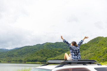 Young Asian woman enjoy and fun outdoor lifestyle road trip and camping in forest mountain on...