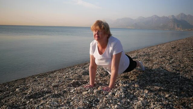 woman doing yoga performing asanas and enjoying life on the beach sea, sunset time