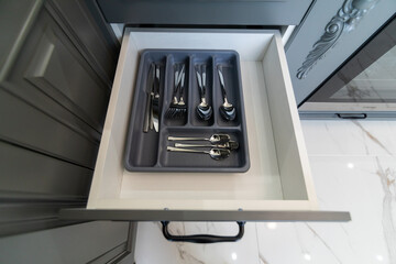 Open cupboard with cutlery inside