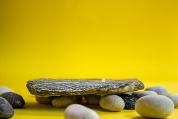 Stone podium for product display. Empty showcase or pedestal isolated on yellow background. Copy space for advertising text.