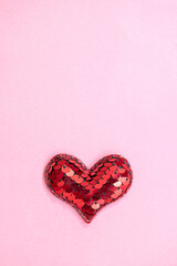 Red heart on pink paper.  vertical photo