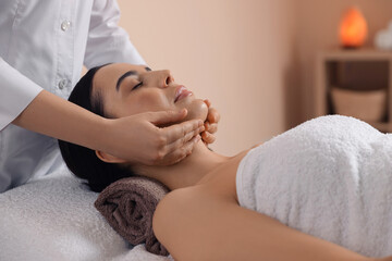 Fototapeta na wymiar Young woman enjoying professional massage in spa salon