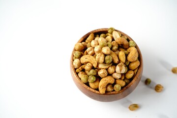 Cocktail nuts mix served in a wooden bowl, selective focus