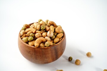 Cocktail nuts mix served in a wooden bowl, selective focus