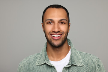 Obraz premium Portrait of smiling African American man on light grey background