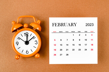 The February 2023 Monthly calendar for the organizer to plan 2023 year with alarm clock on yellow background.