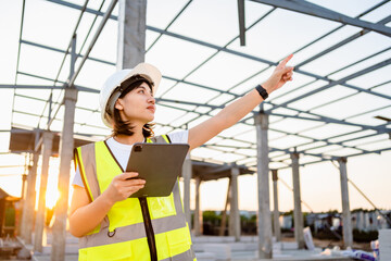 Fototapeta na wymiar Civil Engineer women in safety suite use a digital tablet to work inspection and quality control on construction site .contractor and developer real estate concept