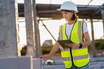 Civil Engineer women in safety suite use a digital tablet to work inspection and quality control on construction site .contractor and developer real estate concept