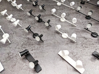 Lots of white and black lamps on the wall. Electrical goods, chandeliers, electric light store.