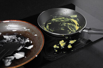 Dirty frying pans on cooktop in kitchen
