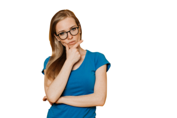Thoughtful redhead young woman in glasses, dressed in blue t-shirt, supports her head by hand, makes a decision, stands over transparent background. People sincere emotions. Upset lady looks at camera