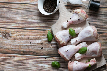 Raw chicken legs, with spices, on a wooden background