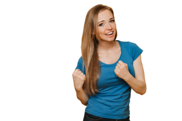 Adorable young American redhead woman in blue t-shirt and jeans, smiling broadly, clenching her fists in success mood, celebrates her win, stands over transparent background. Happy people concept.