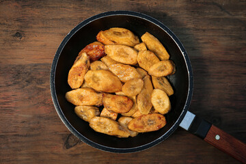 Tasty deep fried banana slices on wooden table, top view