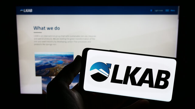 Stuttgart, Germany - 01-12-2023: Person holding mobile phone with logo of company Luossavaara-Kiirunavaara AB (LKAB) on screen in front of web page. Focus on phone display.