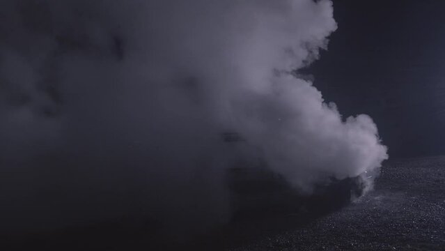 White smoke from a fire on a car rising on a black background in slow motion recorded with the RED camera. High quality 4k footage