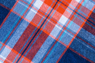 Orange, white, blue texture background. Shirt fabric with a checkered pattern. Factory material.