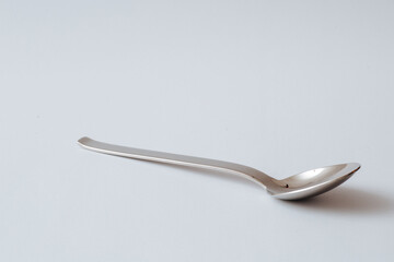Silver shiny spoon on white background, kitchenware, copy space