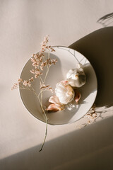 Organic Natural Garlic Cloves and dried flowers on plate in afternoon sunlight