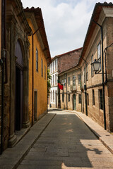 Fototapeta na wymiar Street of ancient portuguese town with portuguese flag