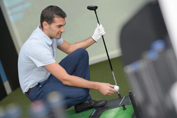 man playing indoor golf