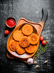 Fish cutlets on a plate with thyme,garlic and tomato sauce.