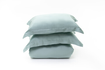 Two pillows in green pillow cases and blanket on white background. Bed linen set