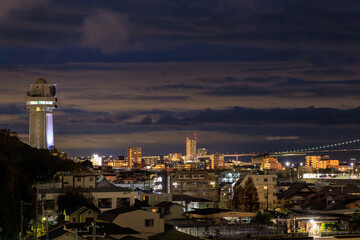 Fototapeta na wymiar Dramatic sky over tower and dense quiet town in blue hour