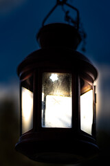Little lantern with glass and a blurred background with lights on at night