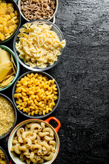 Different types of dry pasta in bowls.