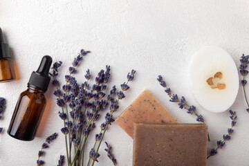Essential oils, handmade soap and lavender flowers on a white textural background. Spa concept. Relaxation and relaxation. Body and skin care. Place for text. Place to copy.