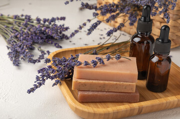 Essential oils, handmade soap and lavender flowers on a white textural background. Spa concept. Relaxation and relaxation. Body and skin care. Place for text. Place to copy.