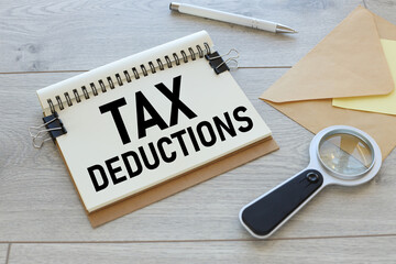 Tax Deductions text on a notebook with a spring. notebook and magnifying glass