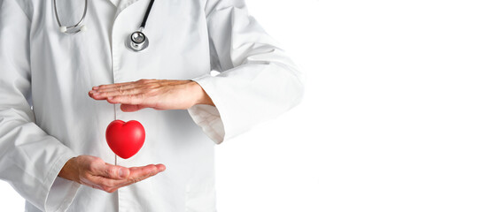 doctor in a white coat protecting with his hands a red heart with a lot of copy space on the right