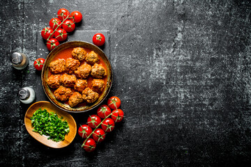 Fototapeta premium Meat balls with tomatoes and chopped greens in a bowl.