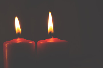 three burning candles on black background