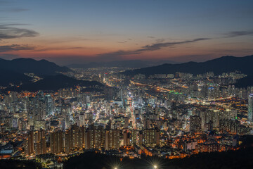 Fototapeta na wymiar Panoramic and Night view of apartments and high-rise buildings at downtown Busan seen from Hwangnyeongsan Mountain in Winter