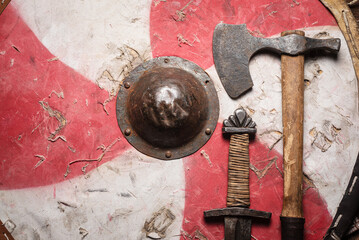 Old battle swords, axe and shield on the wooden table top view background with copy space.