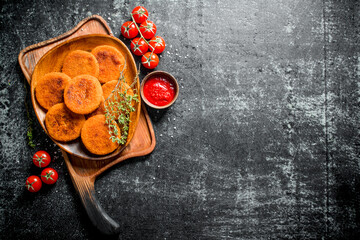 Fish cutlets on a plate with thyme,tomatoes and sauce.