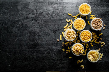 Different types of dry pasta in bowls.