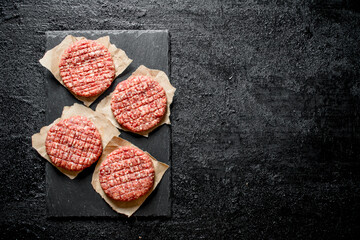 Raw burgers on paper.